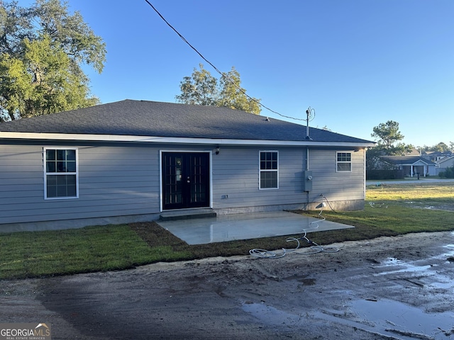 rear view of property featuring a patio and a lawn