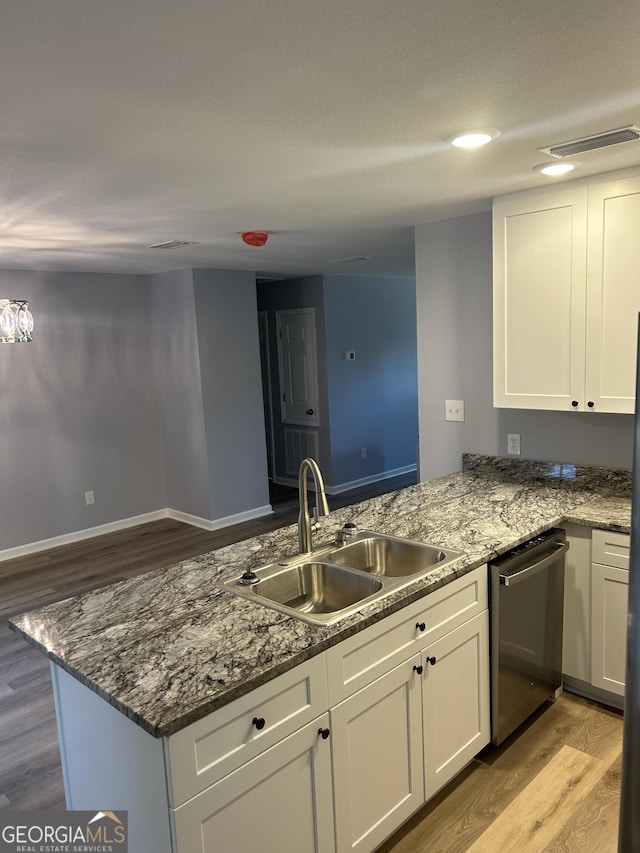 kitchen featuring kitchen peninsula, white cabinets, sink, and dishwasher