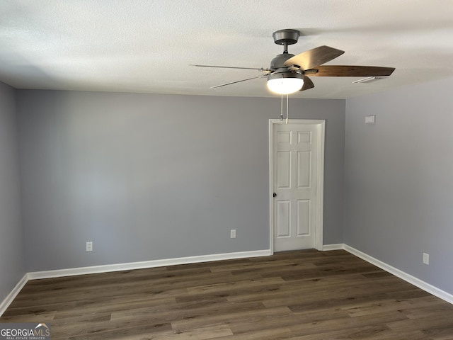 empty room featuring ceiling fan, a textured ceiling, and dark hardwood / wood-style flooring