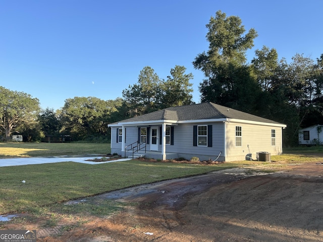 single story home featuring cooling unit and a front yard