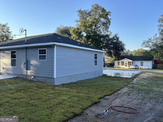 view of property exterior with a patio and a lawn