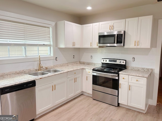 kitchen with sink, light hardwood / wood-style flooring, stainless steel appliances, and white cabinets