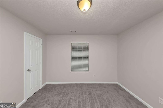 carpeted empty room with a textured ceiling