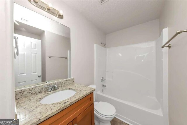 full bathroom with shower / bathing tub combination, a textured ceiling, vanity, and toilet