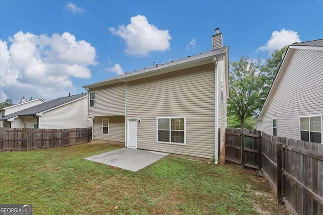 back of house with a patio area and a yard