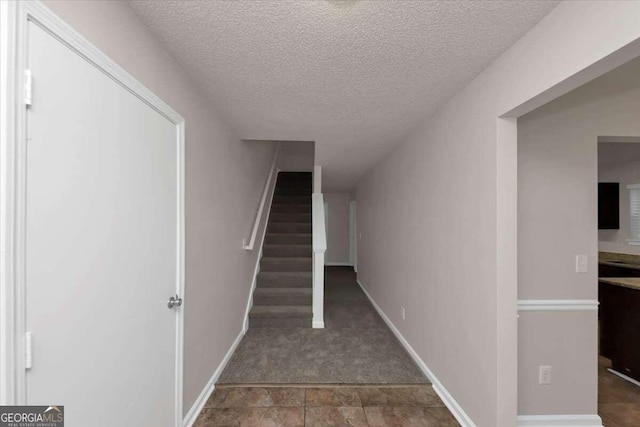 stairs with a textured ceiling