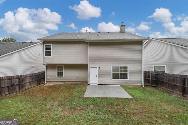 rear view of house with a yard and a patio