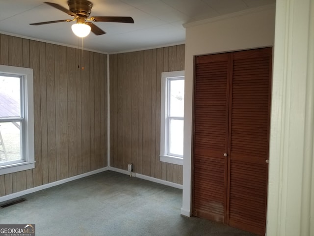 unfurnished bedroom with carpet flooring, multiple windows, ceiling fan, and a closet