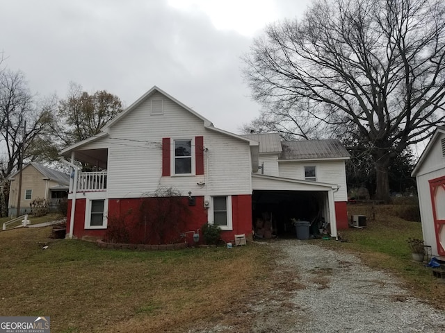 back of property featuring a garage, central AC unit, and a lawn