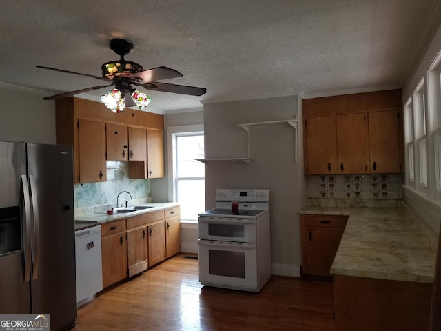 kitchen with white appliances, backsplash, crown molding, sink, and light wood-type flooring