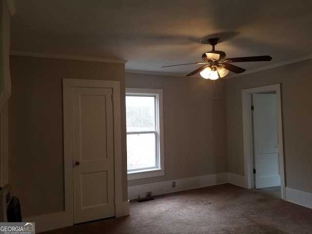 carpeted spare room featuring ceiling fan and ornamental molding