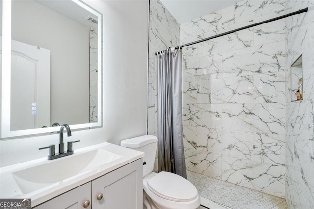 bathroom with walk in shower, vanity, and toilet