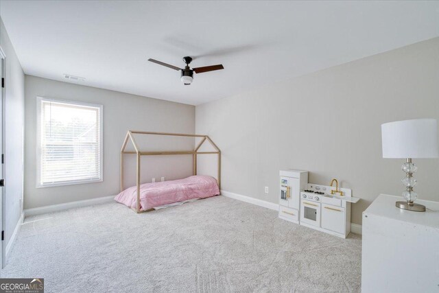 unfurnished bedroom with ceiling fan and light colored carpet