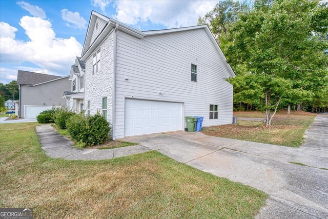 view of home's exterior with a garage and a lawn