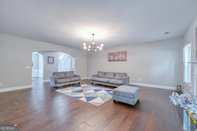 living room featuring dark wood-type flooring and a notable chandelier