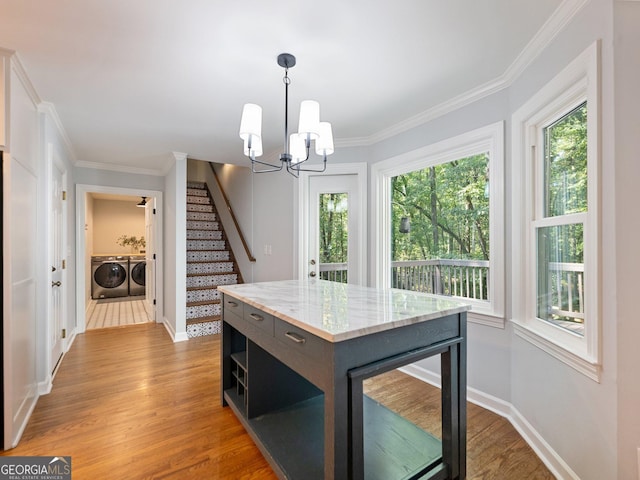 kitchen featuring pendant lighting, separate washer and dryer, an inviting chandelier, hardwood / wood-style flooring, and a center island