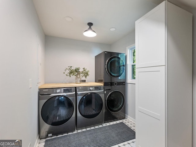 washroom featuring cabinets and stacked washer / drying machine