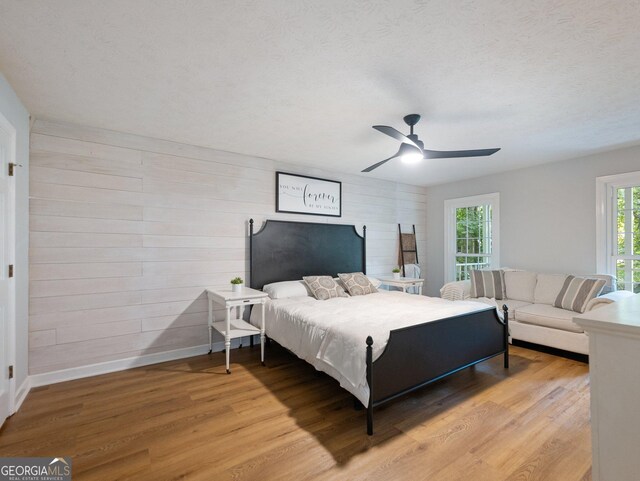 bedroom featuring multiple windows, hardwood / wood-style flooring, and ceiling fan