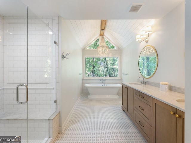 bathroom with a notable chandelier, vanity, separate shower and tub, and vaulted ceiling