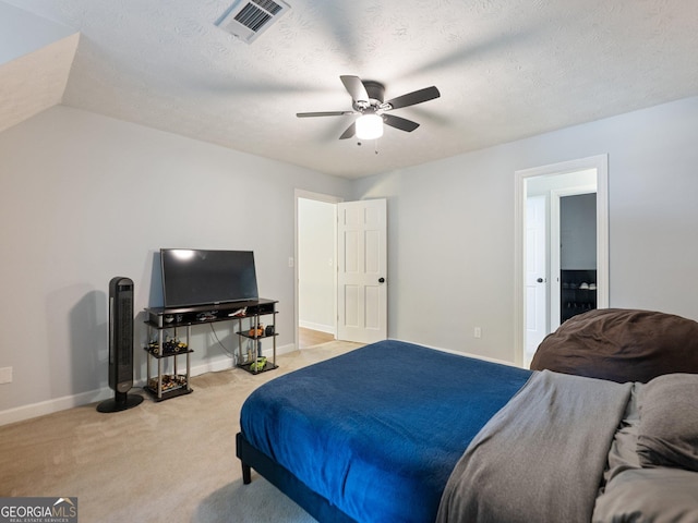 carpeted bedroom with ceiling fan and a textured ceiling