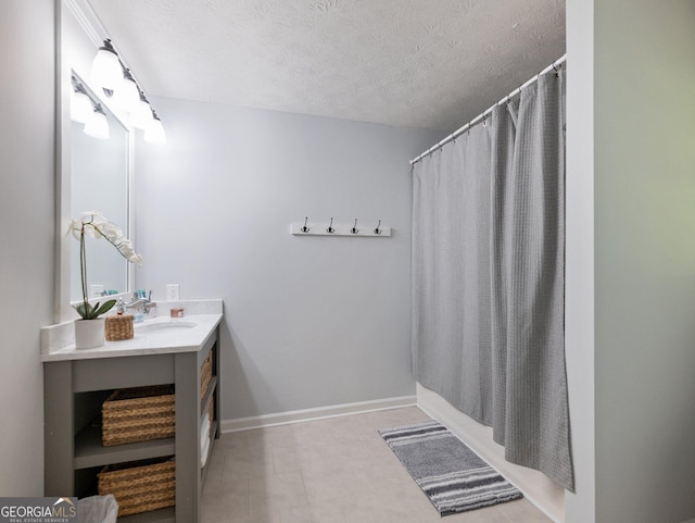 bathroom with a textured ceiling, vanity, and shower / bath combo