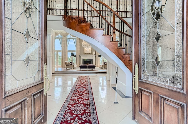 9620 Cedar Grove Rd, Fairburn, GA 30213 - foyer entrance with arched walkways, stairs, inlaid floor details, light tile patterned floors, and a towering ceiling
