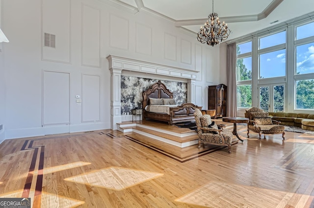 9620 Cedar Grove Rd, Fairburn, GA 30213 - sitting room featuring a chandelier, a decorative wall, wood finished floors, plenty of natural light, and a towering ceiling