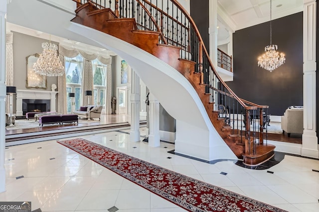 9620 Cedar Grove Rd, Fairburn, GA 30213 - stairway with a chandelier, a high ceiling, tile patterned floors, baseboards, and a fireplace