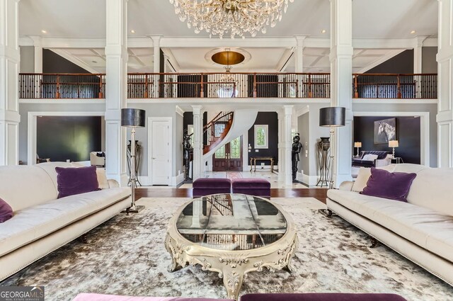 9620 Cedar Grove Rd, Fairburn, GA 30213 - living area with ornate columns, a high ceiling, stairs, a chandelier, and crown molding