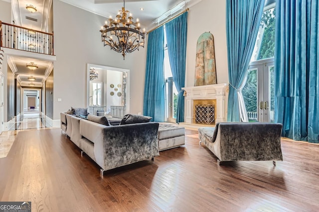 9620 Cedar Grove Rd, Fairburn, GA 30213 - living area featuring a towering ceiling, ornamental molding, wood finished floors, a chandelier, and a fireplace with raised hearth