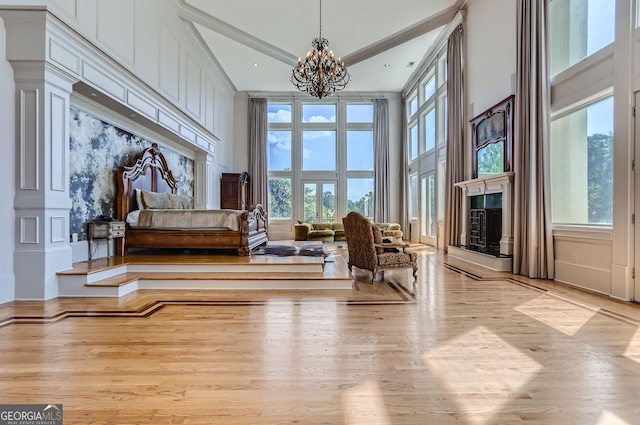 9620 Cedar Grove Rd, Fairburn, GA 30213 - sitting room featuring a fireplace with raised hearth, wood finished floors, a chandelier, and a high ceiling