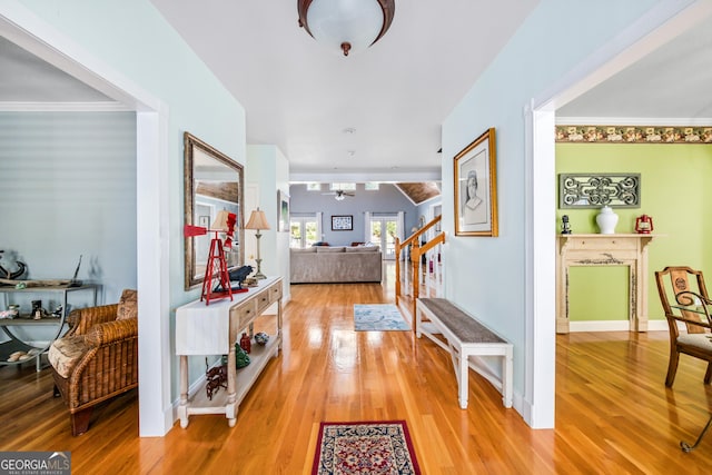 corridor with hardwood / wood-style floors and ornamental molding