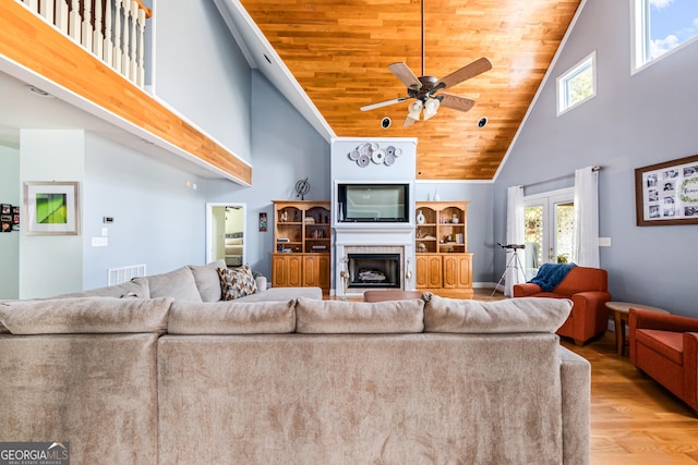 living room featuring wood-type flooring, wooden ceiling, high vaulted ceiling, and ceiling fan