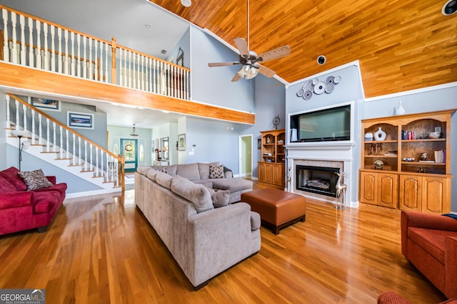 living room with high vaulted ceiling, light hardwood / wood-style floors, ceiling fan, and wood ceiling