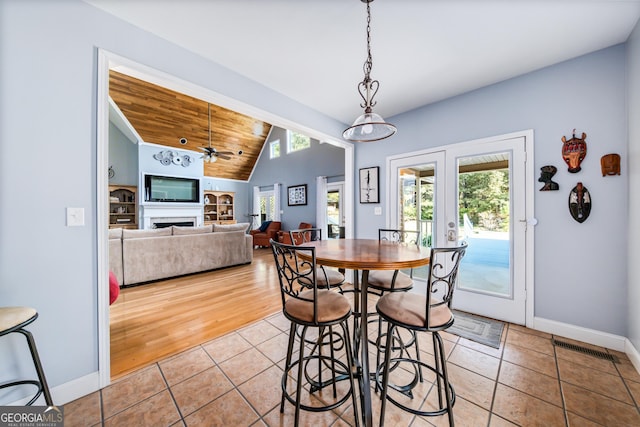 tiled dining room featuring french doors, vaulted ceiling, ceiling fan, and wood ceiling