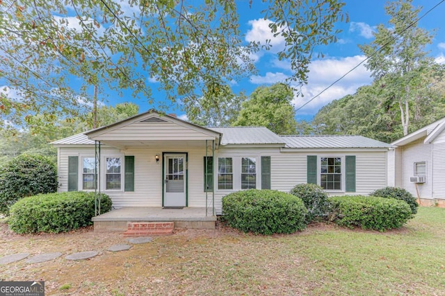 view of front facade featuring cooling unit, a front yard, and a porch