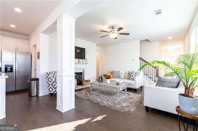 living room featuring ceiling fan and dark wood-type flooring