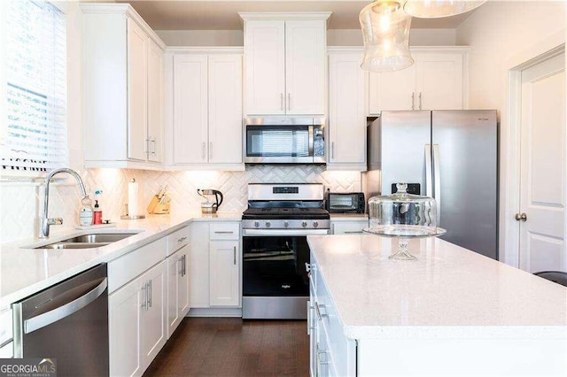 kitchen with white cabinets, appliances with stainless steel finishes, sink, and tasteful backsplash