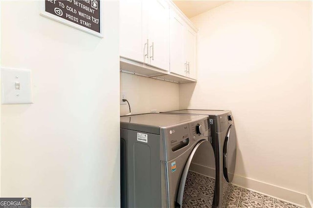 clothes washing area with cabinets and separate washer and dryer