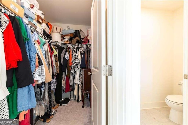 walk in closet with light tile patterned floors