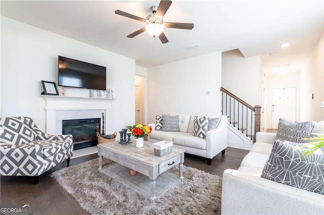 living room with ceiling fan, a fireplace, and dark hardwood / wood-style flooring