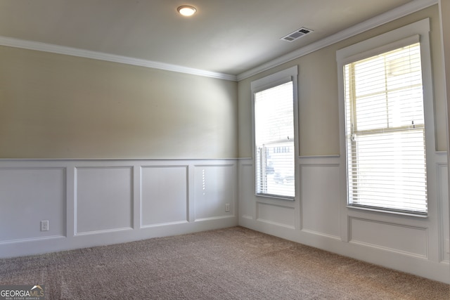 carpeted spare room featuring plenty of natural light and crown molding