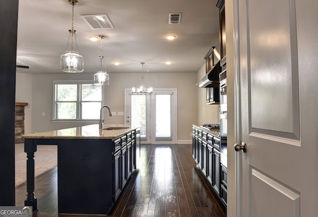 kitchen featuring hanging light fixtures, a center island with sink, sink, and plenty of natural light