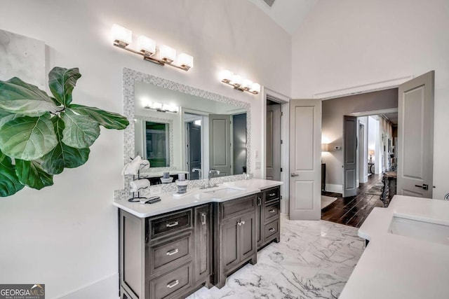 bathroom with vanity, hardwood / wood-style floors, and high vaulted ceiling