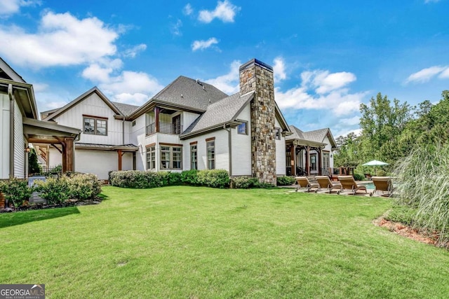 rear view of property featuring a yard and a patio area