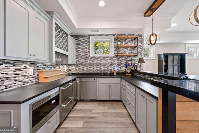 kitchen featuring kitchen peninsula, gray cabinetry, light hardwood / wood-style flooring, appliances with stainless steel finishes, and crown molding