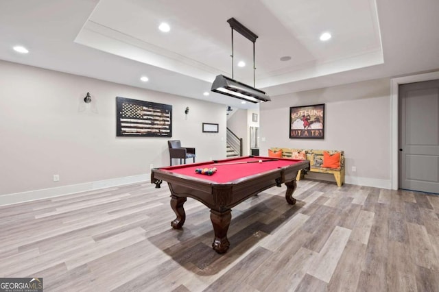 rec room featuring light hardwood / wood-style flooring, pool table, and a tray ceiling