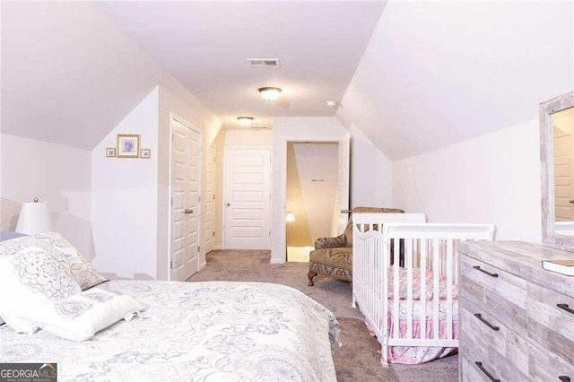 carpeted bedroom with lofted ceiling and a closet