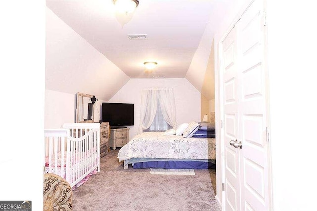 bedroom featuring vaulted ceiling and carpet flooring