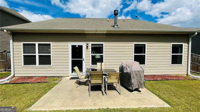 rear view of property featuring a yard and a patio area